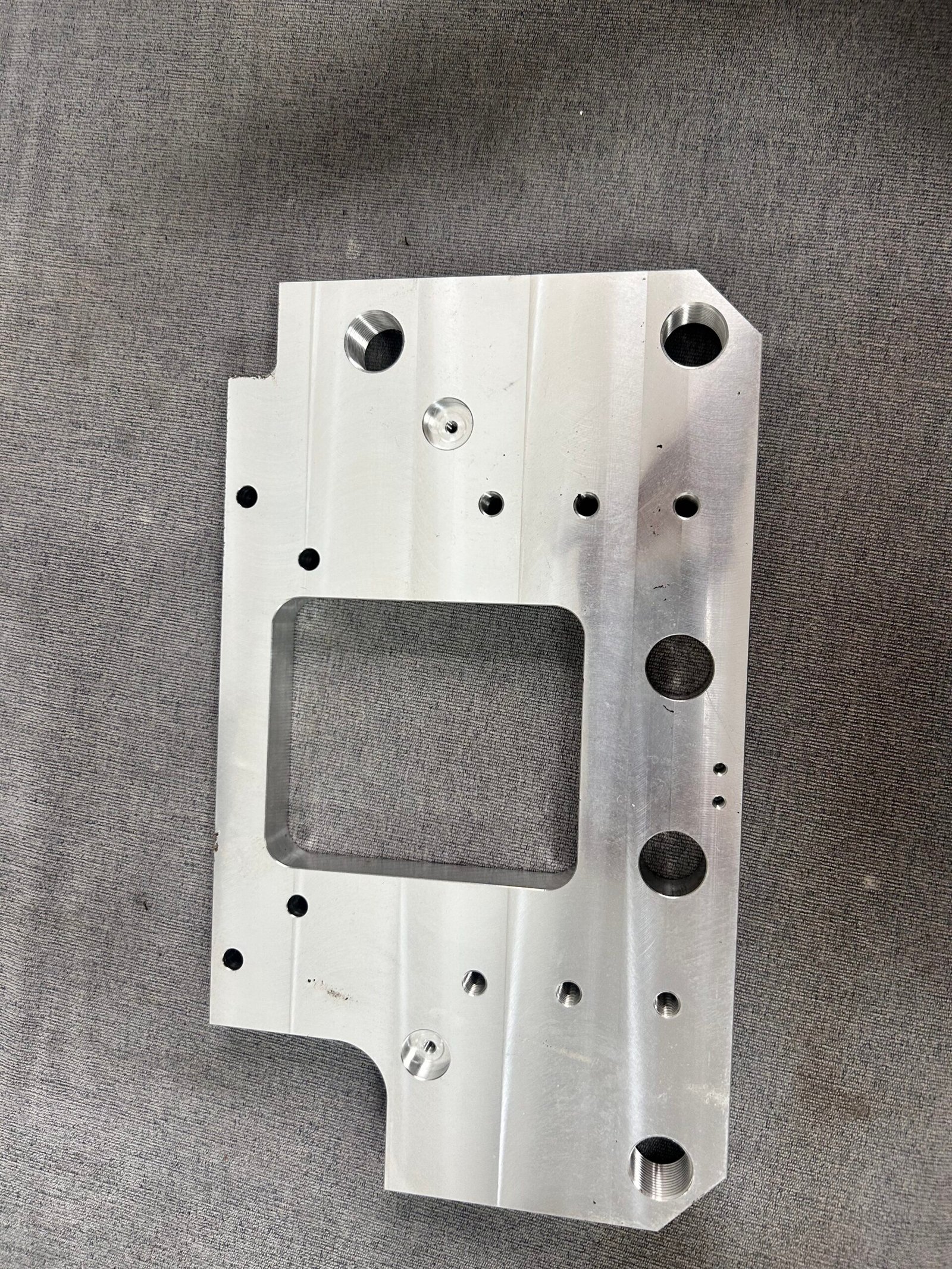 Overall view of a machined windowed plate with multiple holes