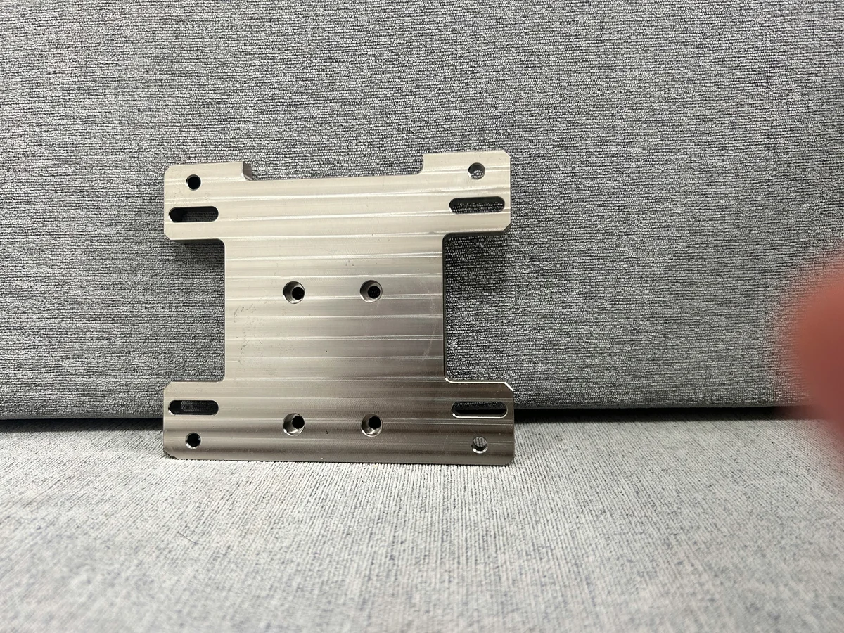 Bridge-shaped machined plate with elongated slots and mounting holes